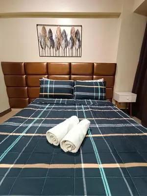 a bedroom with a bed with two towels on it at Palm Tree Two Villas in Manila