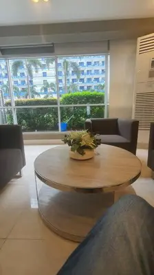 a room with a table and chairs and a large window at EZPlace Sea Residences in Manila