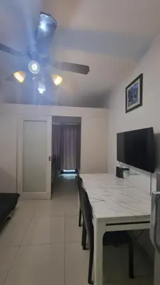 a dining room with a table and a ceiling fan at EZPlace Sea Residences in Manila
