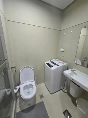 a bathroom with a toilet and a sink at EZPlace Sea Residences in Manila
