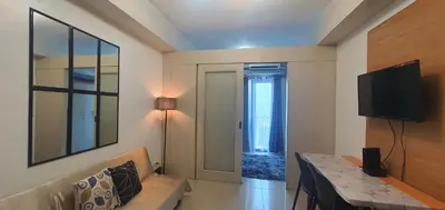 a living room with a couch and a flat screen tv at EZPlace Sea Residences in Manila