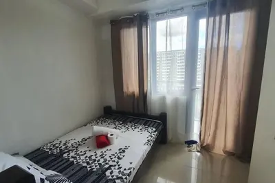 a bedroom with a black and white bed with a window at EZPlace Sea Residences in Manila
