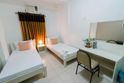 a room with two beds and a desk and a chair at TARASA HOSTEL in Manila