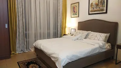 a bedroom with a large bed with white sheets at 150 Newport Boulevard Near NAIA Terminal 3 in Manila