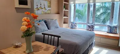 a bedroom with a bed and a table with a vase of flowers at 150 Newport Boulevard Near NAIA Terminal 3 in Manila