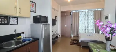a kitchen and living room with a refrigerator in a room at 150 Newport Boulevard Near NAIA Terminal 3 in Manila