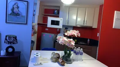 a kitchen with a table with a vase of flowers on it at Affordable Suite at 150 Newport Blvd near NAIA T3 in Manila