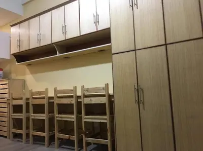 a room with wooden cabinets and chairs in a kitchen at R'Holistay Vista Heights Legarda near CEU San Beda in Manila