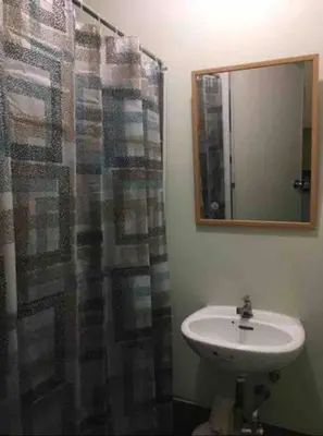 a bathroom with a sink and a shower with a mirror at R'Holistay Vista Heights Legarda near CEU San Beda in Manila