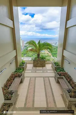 a view of a building with a palm tree in the distance at Torre DeManila TaftAvenue KingBed1bedroomBalcony 65InchesTV Rooftop Viewing LunetaPark ManilaOcean ManilaBay US Embassy in Manila