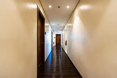 a hallway with wood floors and white walls at MySpace Hotel Comembo Taguig in Manila