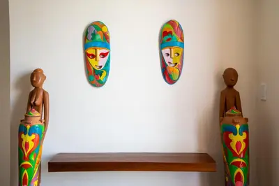 a wall with two statues and two masks on it at MySpace Hotel Comembo Taguig in Manila