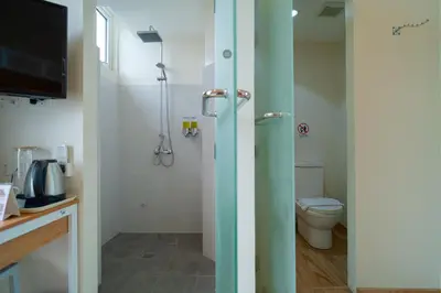 a bathroom with a toilet and a television in it at MySpace Hotel Comembo Taguig in Manila
