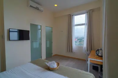 a bedroom with a bed and a window and a desk at MySpace Hotel Comembo Taguig in Manila