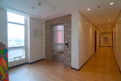an empty hallway with a door and a brick wall at MySpace Hotel Comembo Taguig in Manila