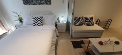 a bedroom with a bed and a couch and a table at JN Condotel The Azure Urban Resort Residences in Manila