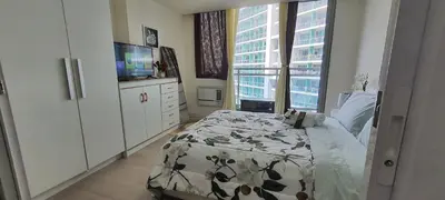 a bedroom with a bed and a flat screen tv at JN Condotel The Azure Urban Resort Residences in Manila