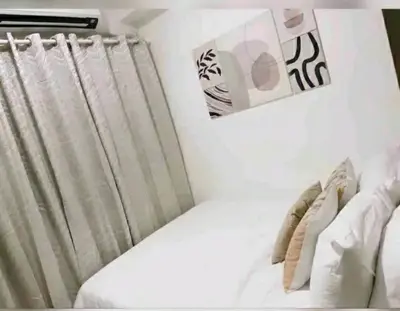 a bedroom with a bed and a window with curtains at Cozy 1BR with balcony at Fame Residences in Manila
