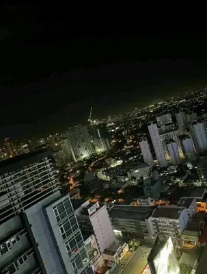 an aerial view of a city at night at Cozy 1BR with balcony at Fame Residences in Manila