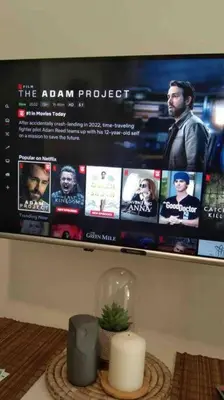 a tv with a movie screen on a wall at Cozy 1BR with balcony at Fame Residences in Manila