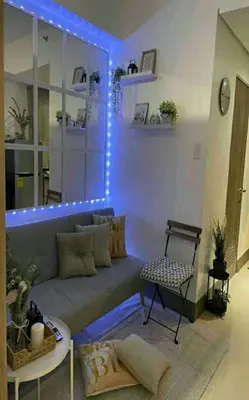 a living room with a couch with lights on it at Cozy 1BR with balcony at Fame Residences in Manila