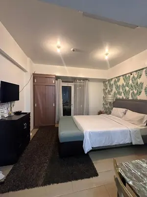 a bedroom with a large bed and a television at Pasay staycation @150Newport in Manila