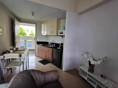 a kitchen and living room with a couch and a table at Pasay staycation @150Newport in Manila