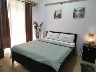 a bedroom with a large bed with two pillows at Pasay staycation @150Newport in Manila