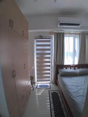 a small bedroom with a bed and a window at SM South Residences, 1 bedroom with balcony. in Manila