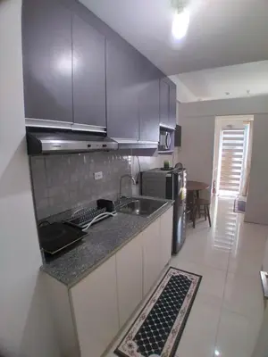 a kitchen with a sink and a counter top at SM South Residences, 1 bedroom with balcony. in Manila