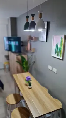 a wooden table with a flower on it in a room at Chic Nordic Condo Unit at Shore Residences Mall of Asia in Manila