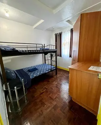 a room with two bunk beds and a wooden floor at Somerset Condominium Tower 1 in Manila