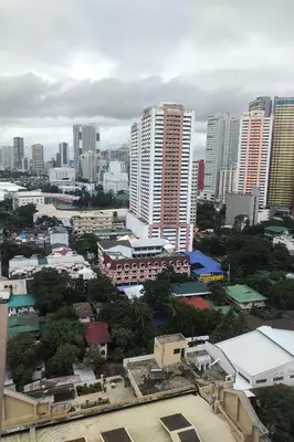 a city skyline with tall buildings and trees at Somerset Condominium Tower 1 in Manila