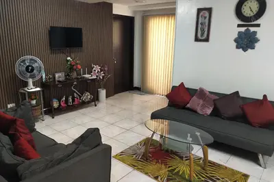 a living room with a couch and a glass table at Somerset Condominium Tower 1 in Manila