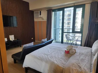 a hotel room with a bed and a large window at palm tree villas in Manila