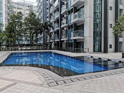 a swimming pool in front of a tall building at palm tree villas in Manila