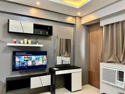 a living room with a flat screen tv on a wall at palm tree villas in Manila