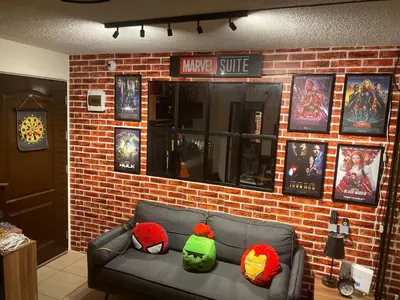 a couch in a room with a brick wall at Marvel Suite Staycation -Near Doña Elena Tower in Manila