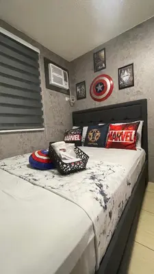 a bedroom with a bed with captain america pillows at Marvel Suite Staycation -Near Doña Elena Tower in Manila