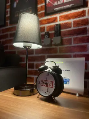 an alarm clock sitting on a table next to a lamp at Marvel Suite Staycation -Near Doña Elena Tower in Manila