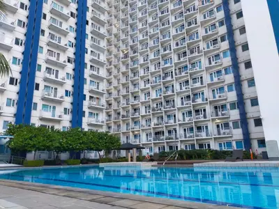 a large apartment building with a large swimming pool at Gabriel's Den @ JazzB1109 in Manila