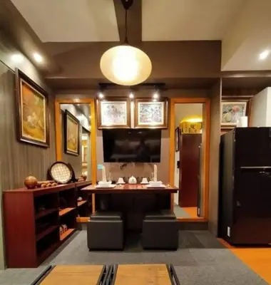 a living room with a table and a television at Stay Amare Green Residences Kristina in Manila