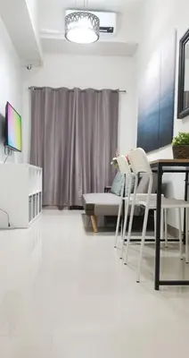 a living room with a table and chairs and a couch at S Residences-MOA in Manila