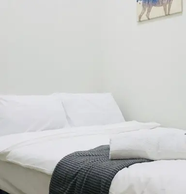 a bed with white sheets and a picture of a cow at S Residences-MOA in Manila