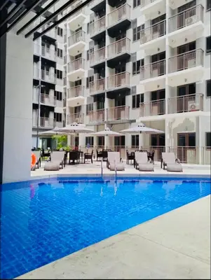a hotel with a swimming pool with chairs and umbrellas at S Residences-MOA in Manila