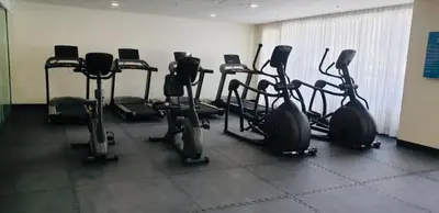 a gym with several cardio machines in a room at S Residences-MOA in Manila