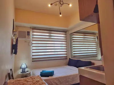 a small bedroom with a bed and a sink at Great View@Fully Equipped Condo w/ WiFi NETFLIX @the Metro in Manila