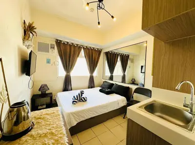 a bedroom with a bed and a sink and a kitchen at Great View@Fully Equipped Condo w/ WiFi NETFLIX @the Metro in Manila