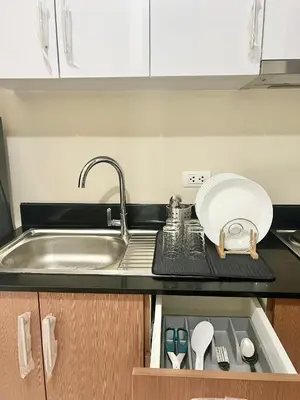 a kitchen counter with a sink and a plate and utensils at Luxury Hotel Type Condo near NAIA Manila Airport in Manila
