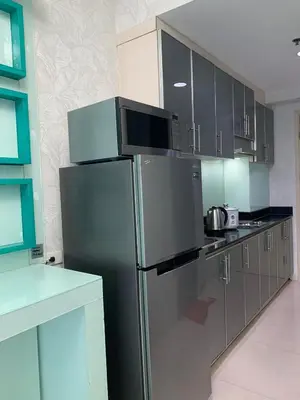 a kitchen with a stainless steel refrigerator and cabinets at Sea Residences in Manila